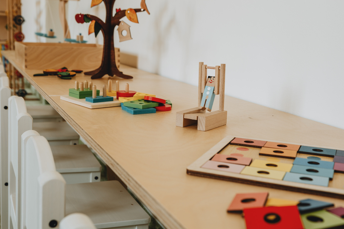 The wooden desk with wooden montessori toys on it in the montessori kindergarten